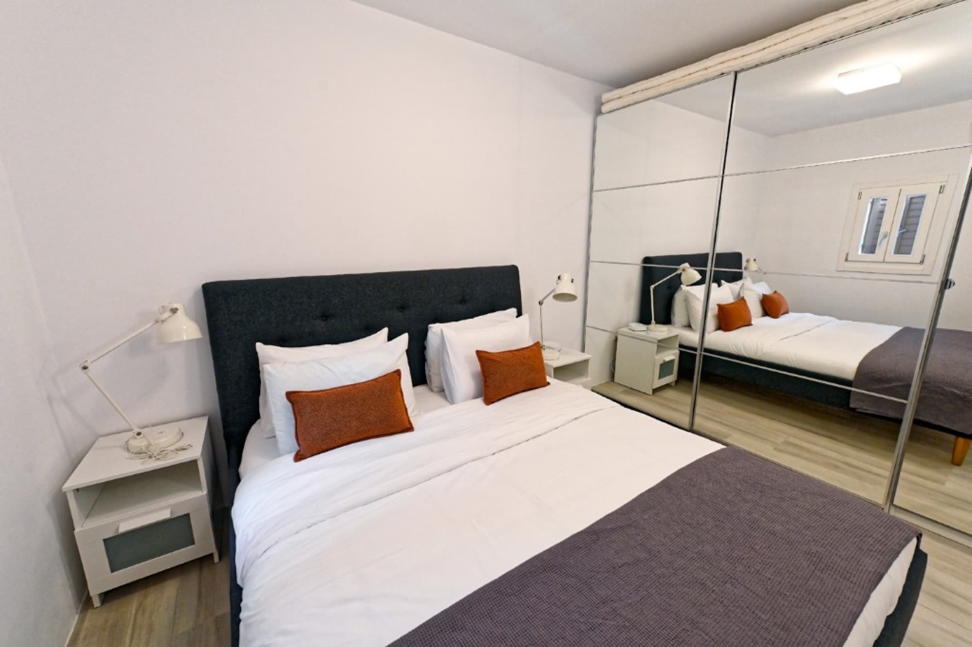 Bedroom with mirrored wardrobe at Hedoni Mykonos
